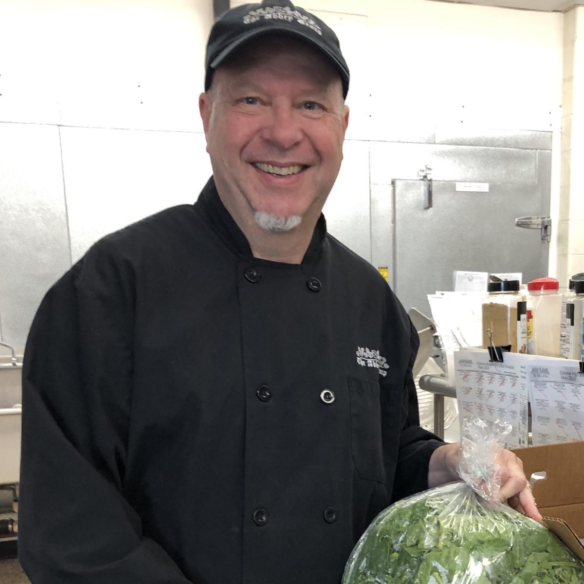 Food Service Director Bob Hildebrand holds local spinach (a Harvest of the Month product) grown at Joe’s Brook Farm and sourced through Green Mountain Farm Direct.