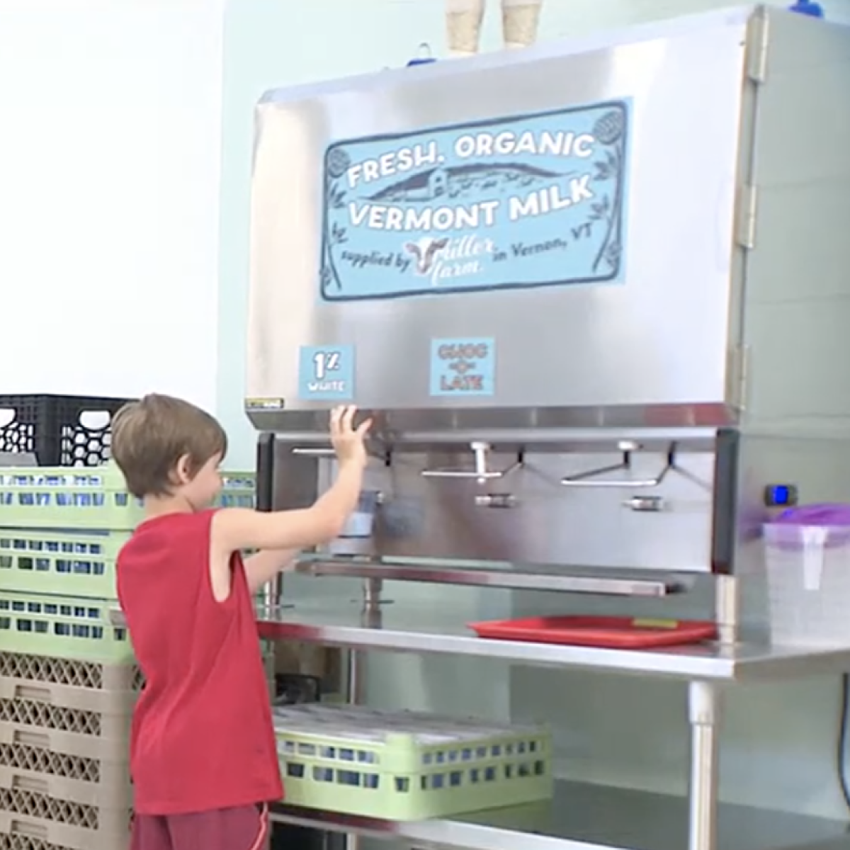 Student pours milk from a cafeteria bulk container