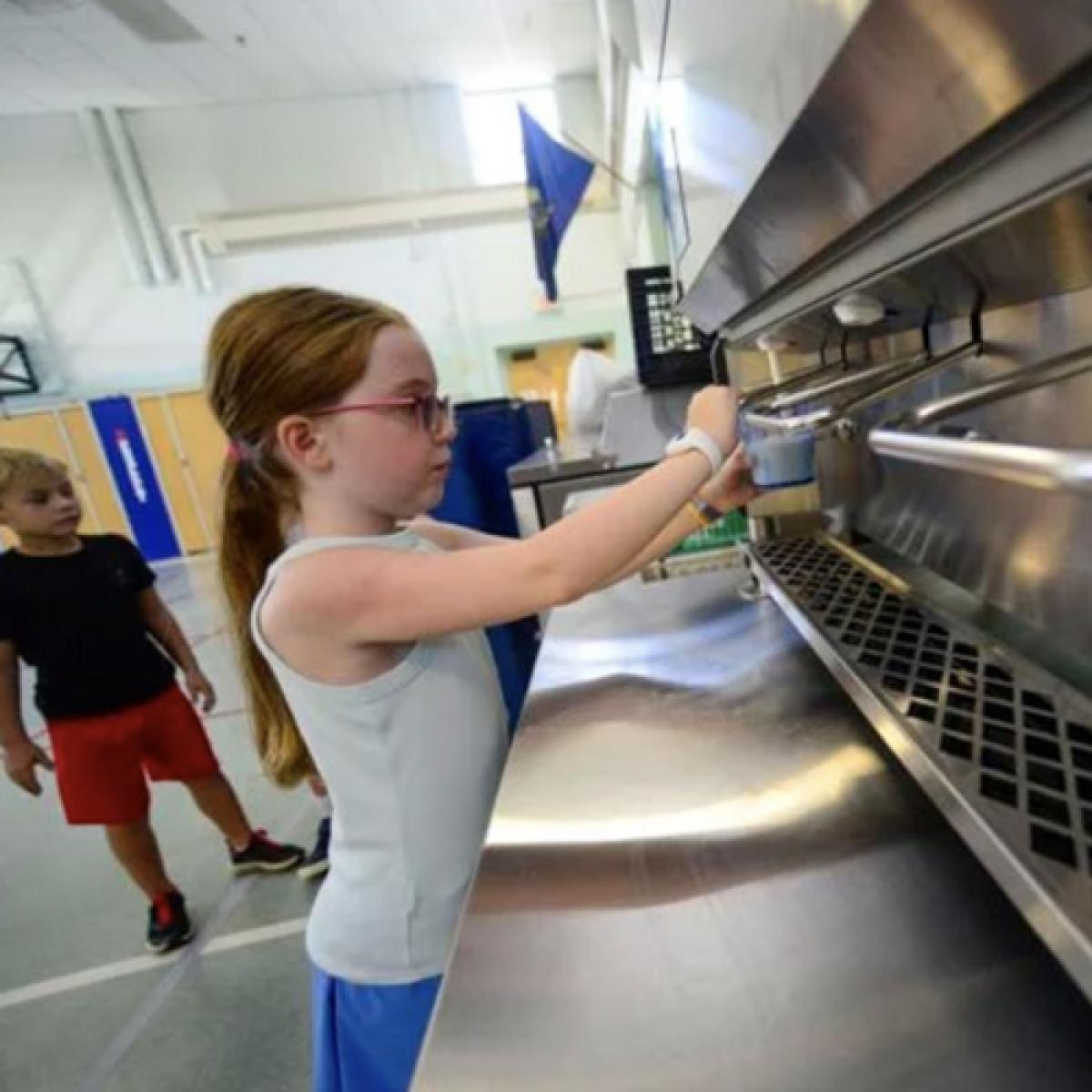 a student dispenses milk from a stainless steel machine