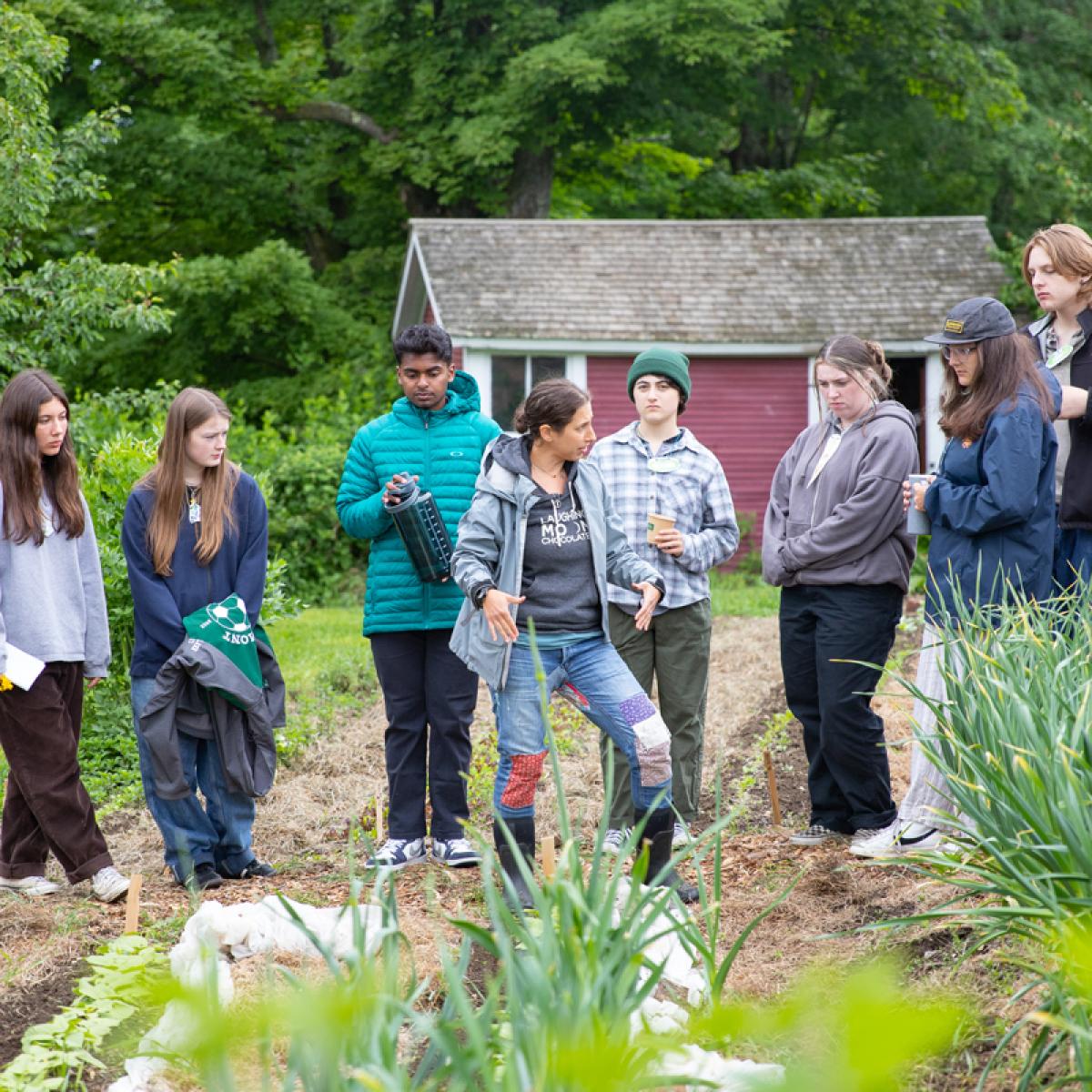 Students and educators gather near a garden