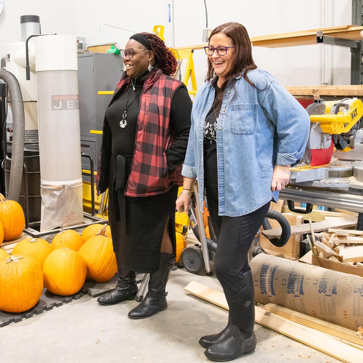 outh Employment Specialist Nashanda McGee-Browman (left) and Student Support Specialist Alyssa Pratt lead a tour through the SEA woodshop, where elements of the school garden space were built by students.