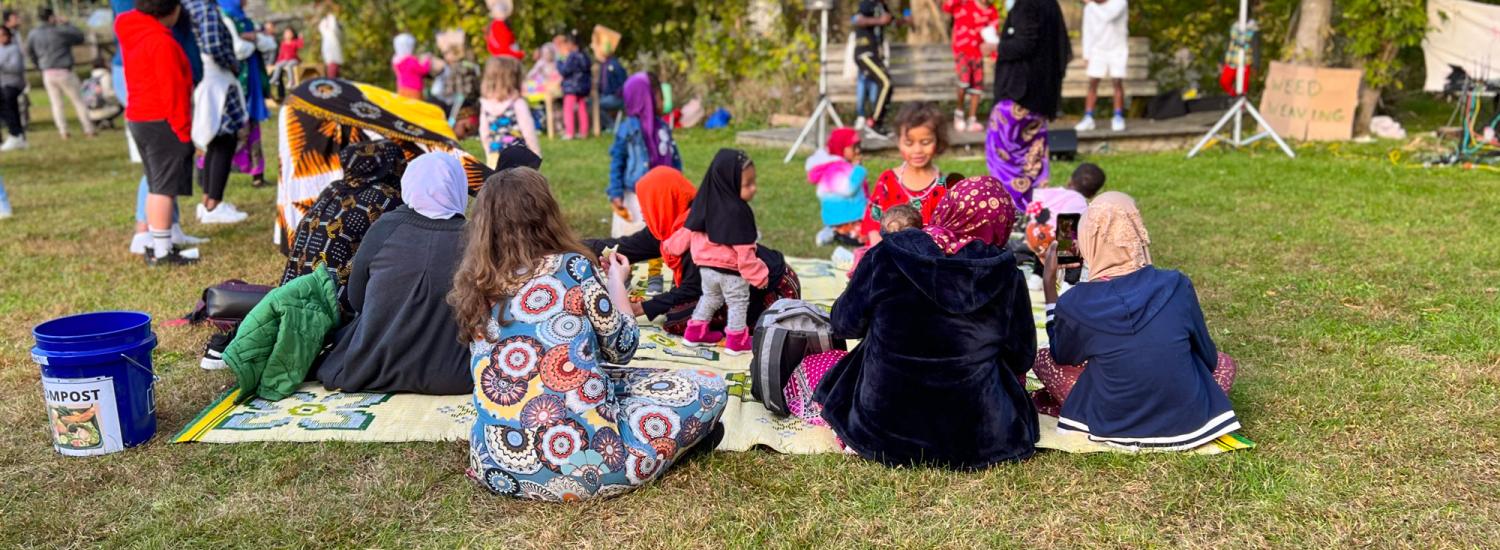 families sit on picnic blankets at an outdoor fall event