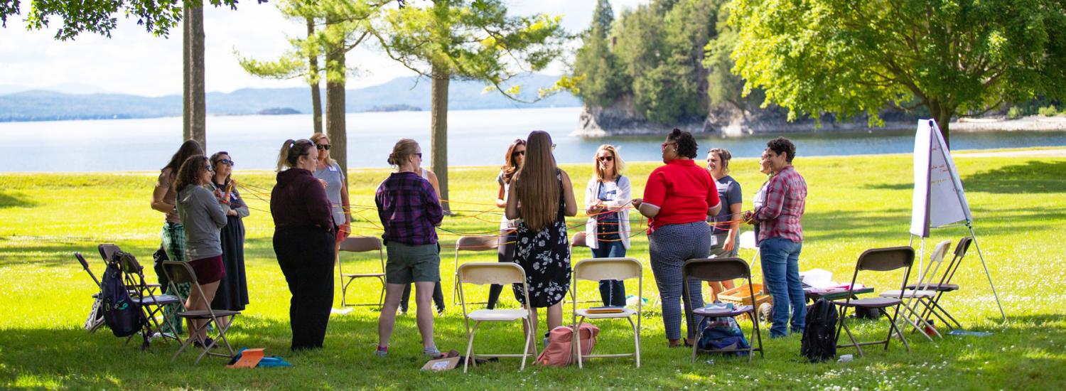 Educators gather outdoors at a recent Northeast Farm to School Institute summer retreat, learning together on the shores of Lake Champlain.