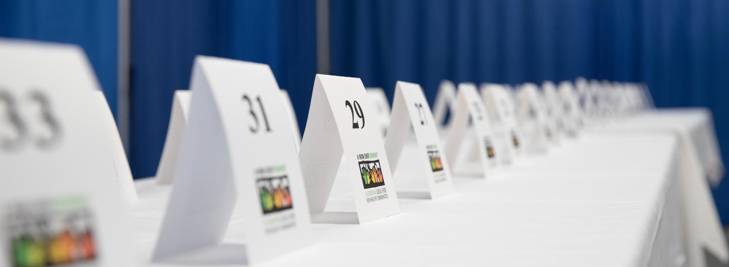 small table number signs lined up on a white linen covered table